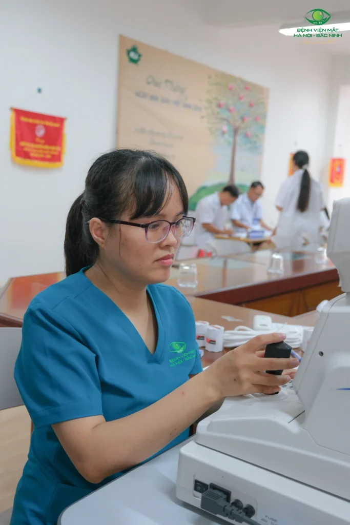 Nhân viên bệnh viện thao tác tại thiết bị kiểm tra mắt trong chương trình DTNT.