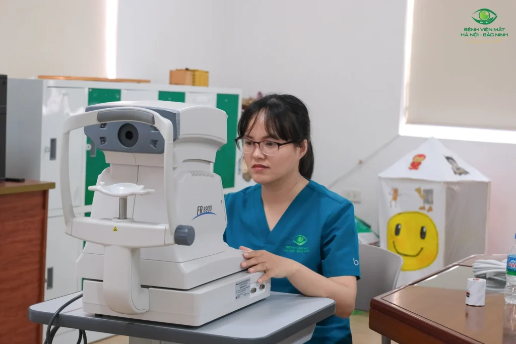 Nhân viên Bệnh viện Mắt Hà Nội – Bắc Ninh bên máy đo khúc xạ tại trường.