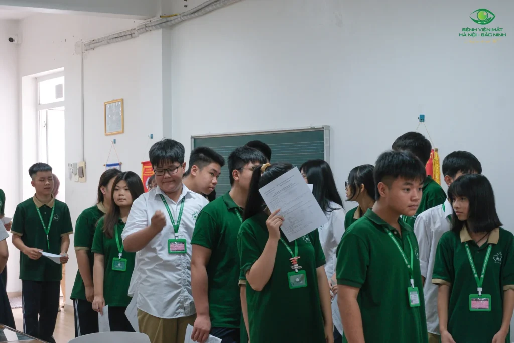 Các em học sinh chờ đến lượt tham gia kiểm tra mắt tại trường.