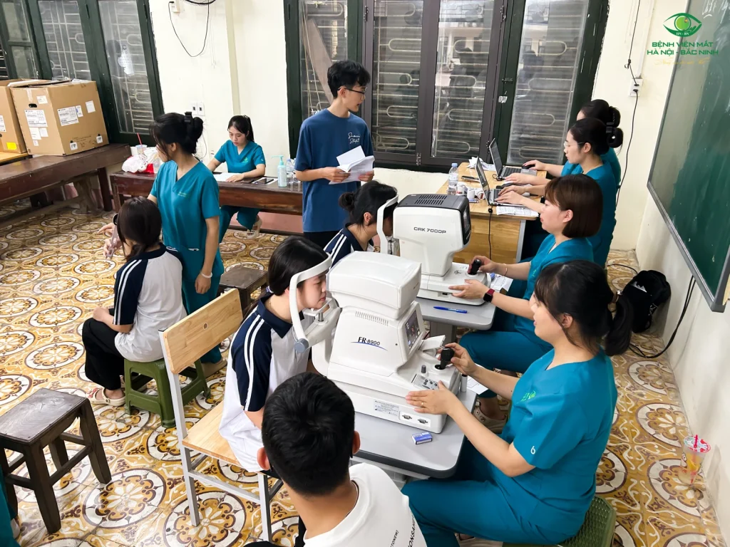 Đội ngũ Bệnh viện Mắt Hà Nội – Bắc Ninh hỗ trợ học sinh đo khúc xạ bằng thiết bị.